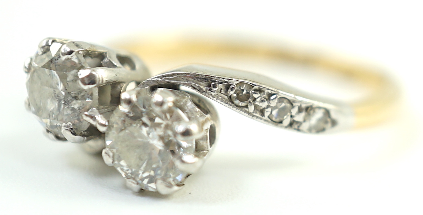 A mid 20th century 18ct gold, platinum and two stone diamond set crossover ring